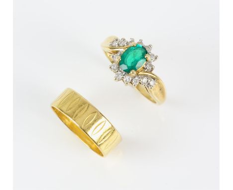 Diamond and synthetic emerald twist ring, central oval cut emerald with a surround of round brilliant diamonds in a fancy flo