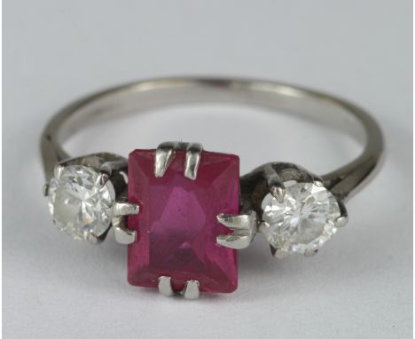Ladies Palladium Ruby and Diamond three stone ring with an oblong shaped synthetic ? ruby flanked by two 0.33ct diamonds (app