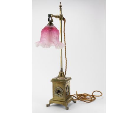 Lamp. An unusual brass lamp, plinth to base decorated with wreaths, holding a pole and adjustable height cranberry coloured g