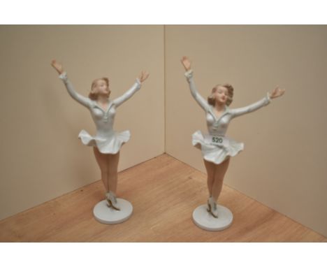 A pair of German Wallendorf porcelain ice skater figurines, modelled in victorious pose with arm held aloft, printed green fa