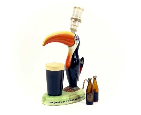 A Carltonware Guinness toucan table lamp. On an oval base with printed authority mark to the base, height 30.5cm, together wi