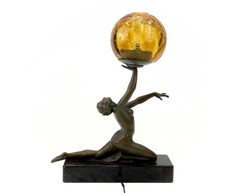 An Art Deco style table lamp.  Modelled as a female figure holding an amber glass ball, on a rectangular marble base. Height 