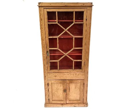 A Victorian pine display cabinet. The upper part with astragal glazed door enclosing three shelves, the lower part with two p