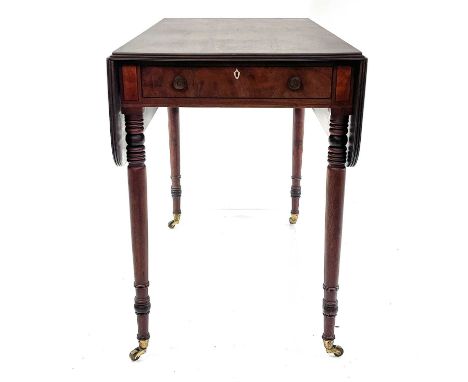 A George III mahogany Pembroke table. Fitted with one real and one dummy drawer and raised on turned taper legs with casters,