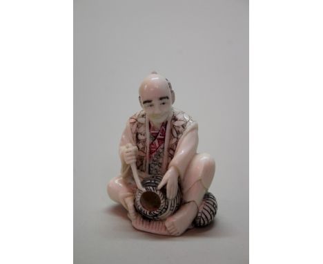 Two Japanese carved ivory netsuke, comprising: a shishi and ball, signed, 4.9cm high; a basket maker, signed, 5cm high; toget