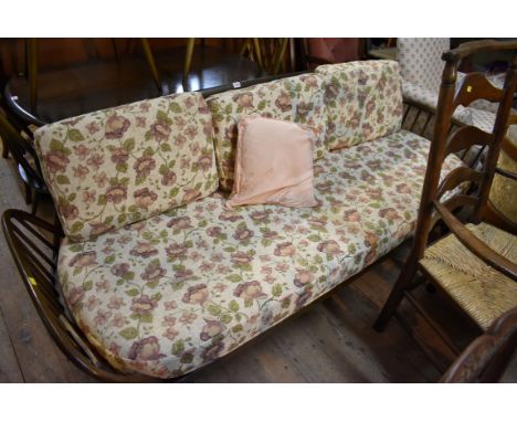 An Ercol elm three seater settee, 205.5cm wide.  Condition Report: Condition commensurate with age and use.  Some minor wear 
