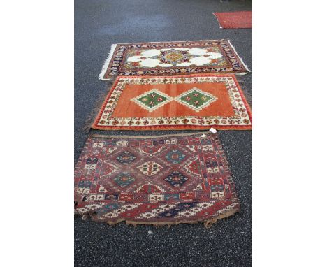 A Persian carpet fragment; together with two modern rugs, largest 187 x 118cm. 