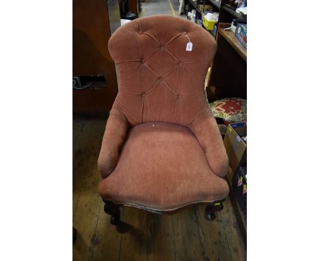 A Victorian walnut and button upholstered low occasional chair.