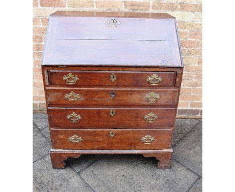 A GEORGE III PROVINICIAL OAK BUREAU with fitted interior above four long graduated drawers, on bracket feet, H 104cm x W 84cm