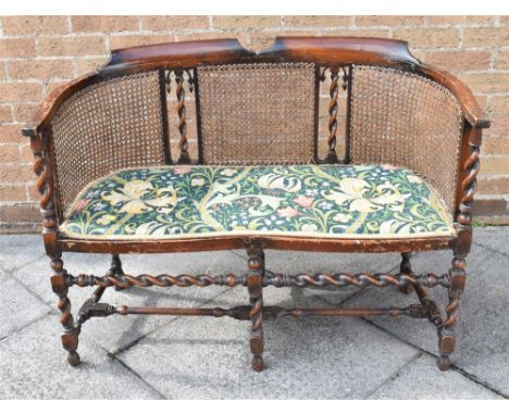 TWO SEATER SOFA, having a floral upholstered seat and with a cane back and raised on six barley twist legs united by a stretc