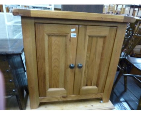 A MODERN LIGHT OAK TWO DOOR CABINET