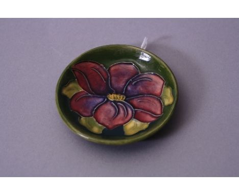A SMALL MOORCROFT TRINKET DISH, Clematis pattern on green ground, diameter approximately 8cm