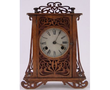 A French Art Nouveau stained wood fretwork cased mantel clock,8-day striking movement, overall height 26cm.
