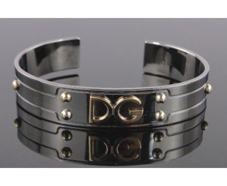 A Dolce & Gabbana titanium and gold monogram bangle, boxed.