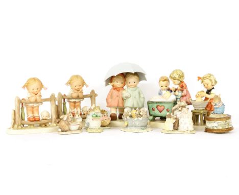 A group of Goebel and Lucie Attwell figures, to include a model of a young girl leaning over a fence with puppy beside and a 