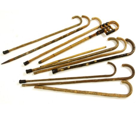 A vintage bamboo shooting stick, together with a collection of walking sticks