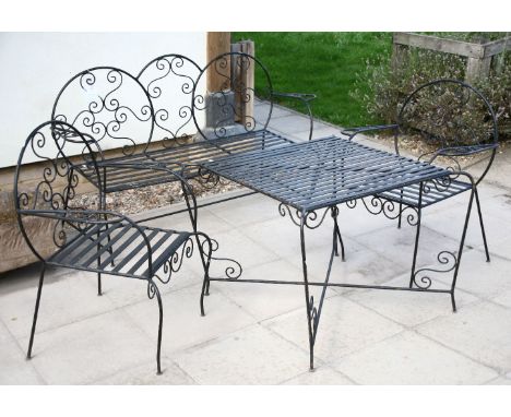 A French wrought iron garden suite, comprising a bench, two armchairs, a square topped table, all on scrollwork supports, ben