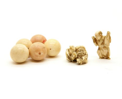 A Japanese ivory netsuke, c.1880, of Daikoku kneeling and thrashing about with his mallet as a kitten chases a rabbit, signed