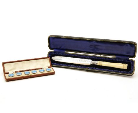 A silver and ivory handled breadknife, cased and a set of six silver and enamel buttons