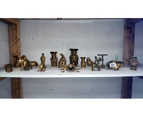 A shelf of assorted brass ornaments