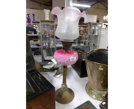 A  Victorian oil lamp with art nouveau pink glass font, brass column, brass base and later shade