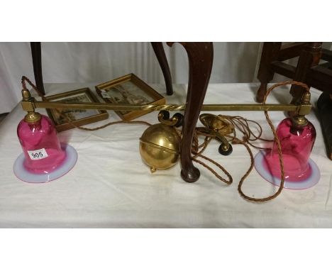 A 1930's double brass rise and fall ceiling light with overlaid cranberry glass shades