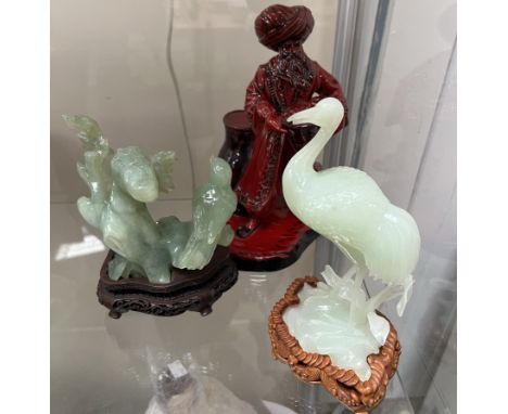 A Royal Doulton flambe figure lamp seller HN3278 together with two jade like hardstone figures of birds