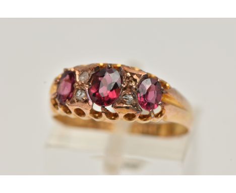 AN EARLY 20TH CENTURY RUBY AND DIAMOND RING, set with three graduated oval cut rubies, interspaced with three rose cut diamon