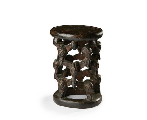 BAMILEKE STOOL CAMEROON 36cm highcarved wood, the circular seat supported by three rows of carved bats heads, with a ring bas