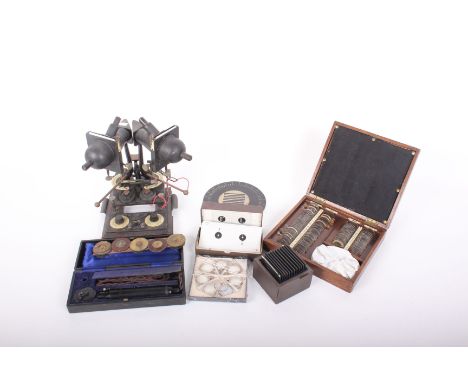 A collection of vintage sight testing equipment including: stereoscopic machine for measuring squints with box of slides, box