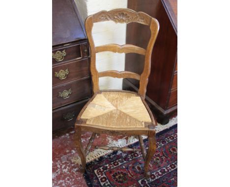 A matched set of eight French oak carved ladder back dining chairs each with rush seat 