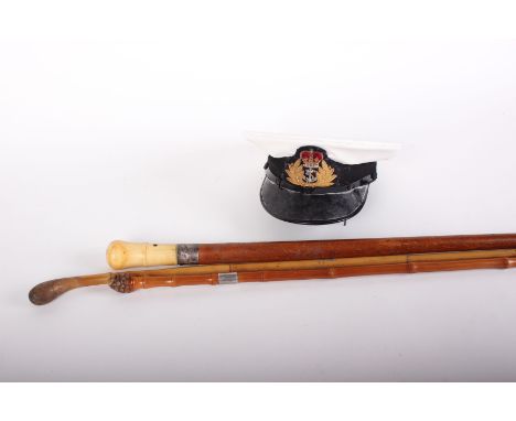 A Naval Officers caps, two swagger sticks and a walking stick presentation inscribed and dated 1891 with ivory handle