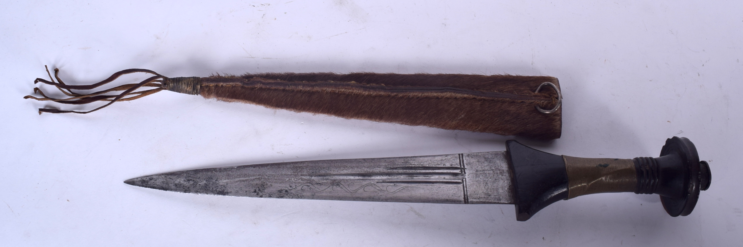 A 19TH CENTURY AFRICAN TRIBAL RITUAL DAGGER, formed with a fur scabbard ...