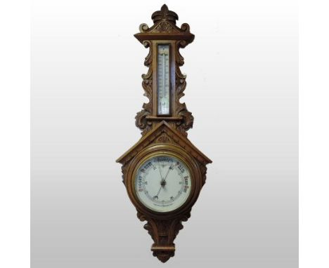 An early 20th century carved oak cased aneroid barometer, 96cm tall