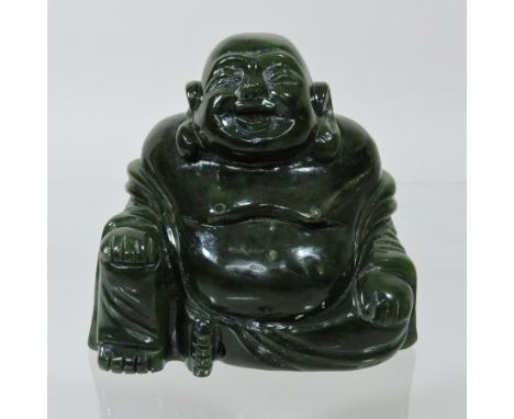 A Chinese carved green jade coloured hardstone figure of Buddha, shown seated with one hand resting on his knee, 10cm tall