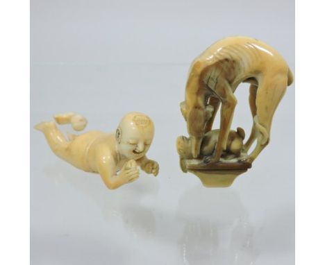 An oriental carved ivory model of a child lying down, 7cm long, together with a figural handle