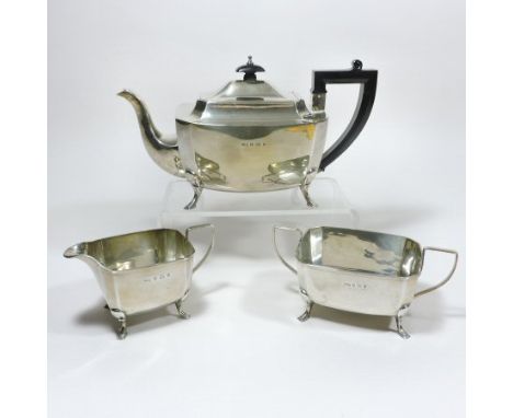 An Art Deco silver three piece tea service, comprising a teapot, 28cm, cream jug and sugar bowl, each of canted rectangular s