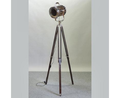 A reproduction chromed stage light, on a tripod base,  approx. 185cm tall