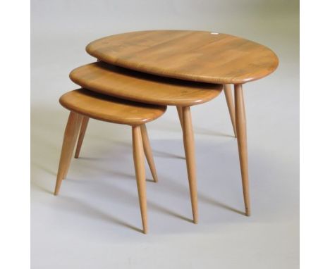 An Ercol light elm nest of three pebble tables, largest 66cm