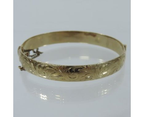 A 9 carat gold engraved hinged bangle