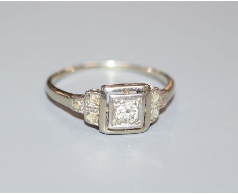 A mid 20th century white metal and single stone diamond ring, with diamond set shoulders, size K.