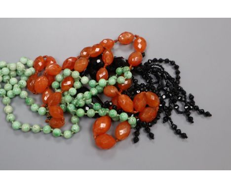 A jade necklace, carnelian necklace and black paste necklace.