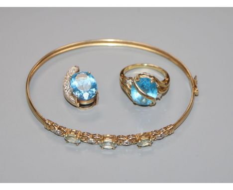 A 9ct gold and blue topaz set dress ring, a similar pendant and a 9k gem set bangle.