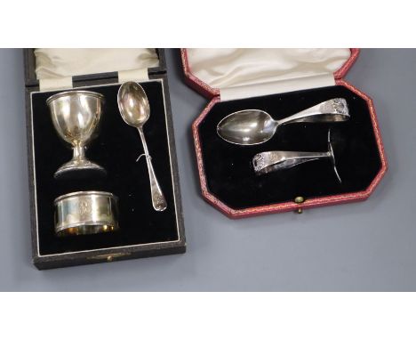 A cased child's silver pusher and similar egg cup spoon and napkin ring.