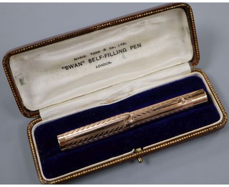 A boxed Swan 9ct gold engine-turned self-filling fountain pen.