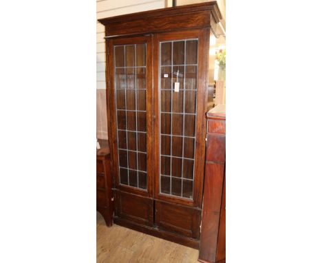 A 1920's oak leaded light bookcase W.96cm