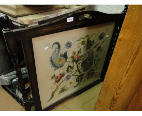 An oak framed firescreen with needlework panel.
