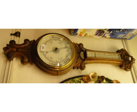 Carved oak cased barometer with thermometer.