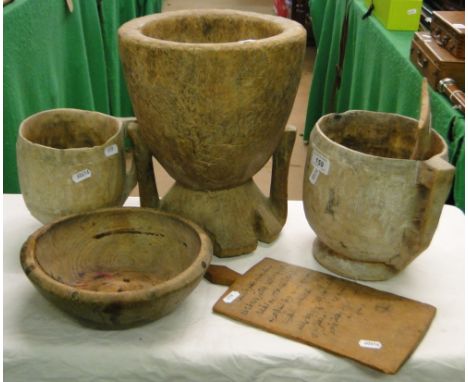 4 African wooden pots, a ladle and a board with lettering.