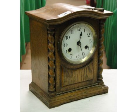 An oak cased 2-train mantel clock with barleytwist columns.